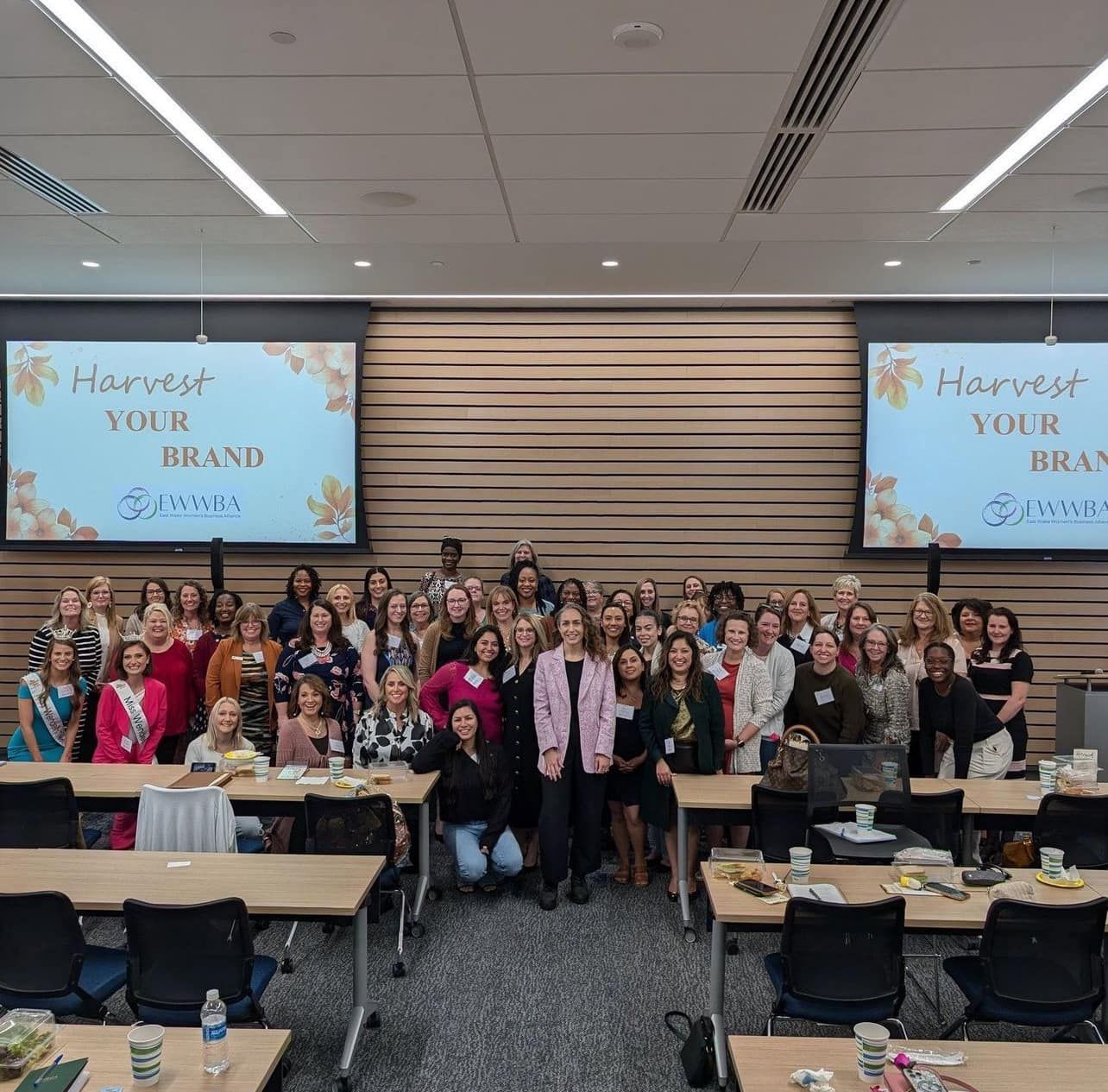 Group of women in a conference room posing for a photo.