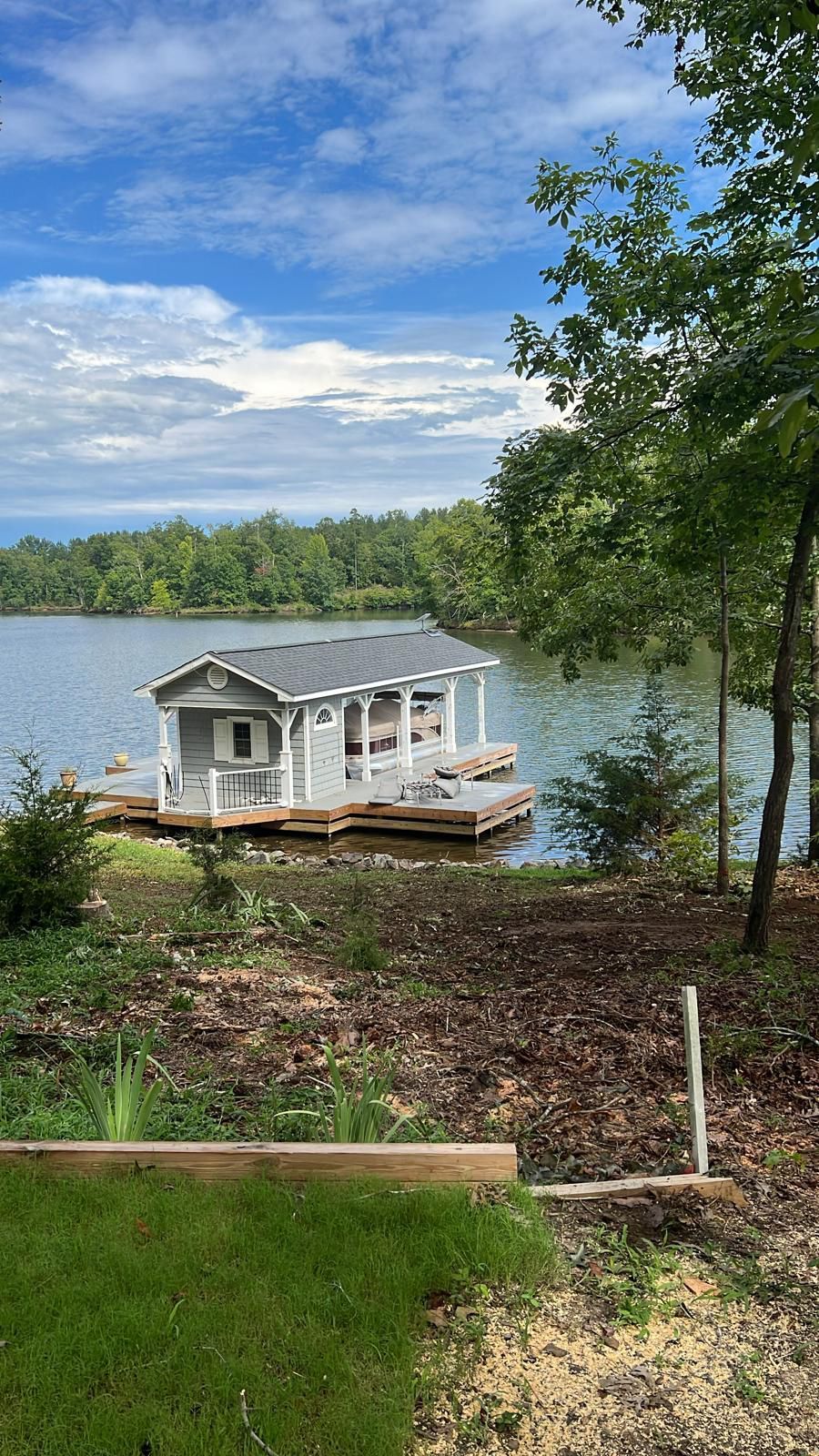 A small house on a dock in the middle of a lake.