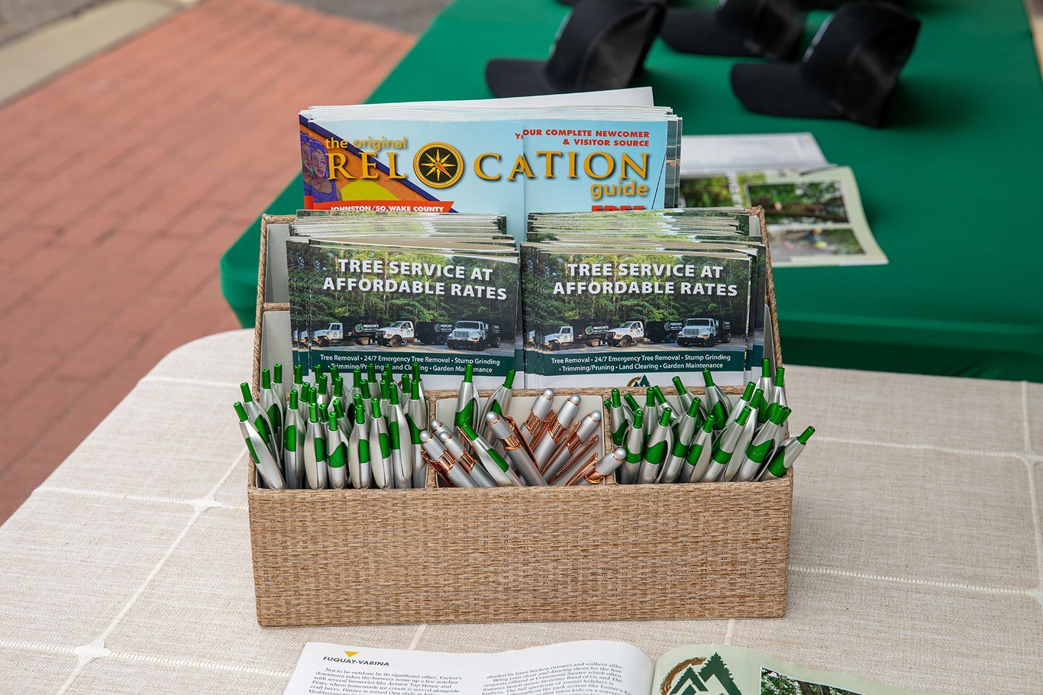 A box of pens and a book titled location on a table