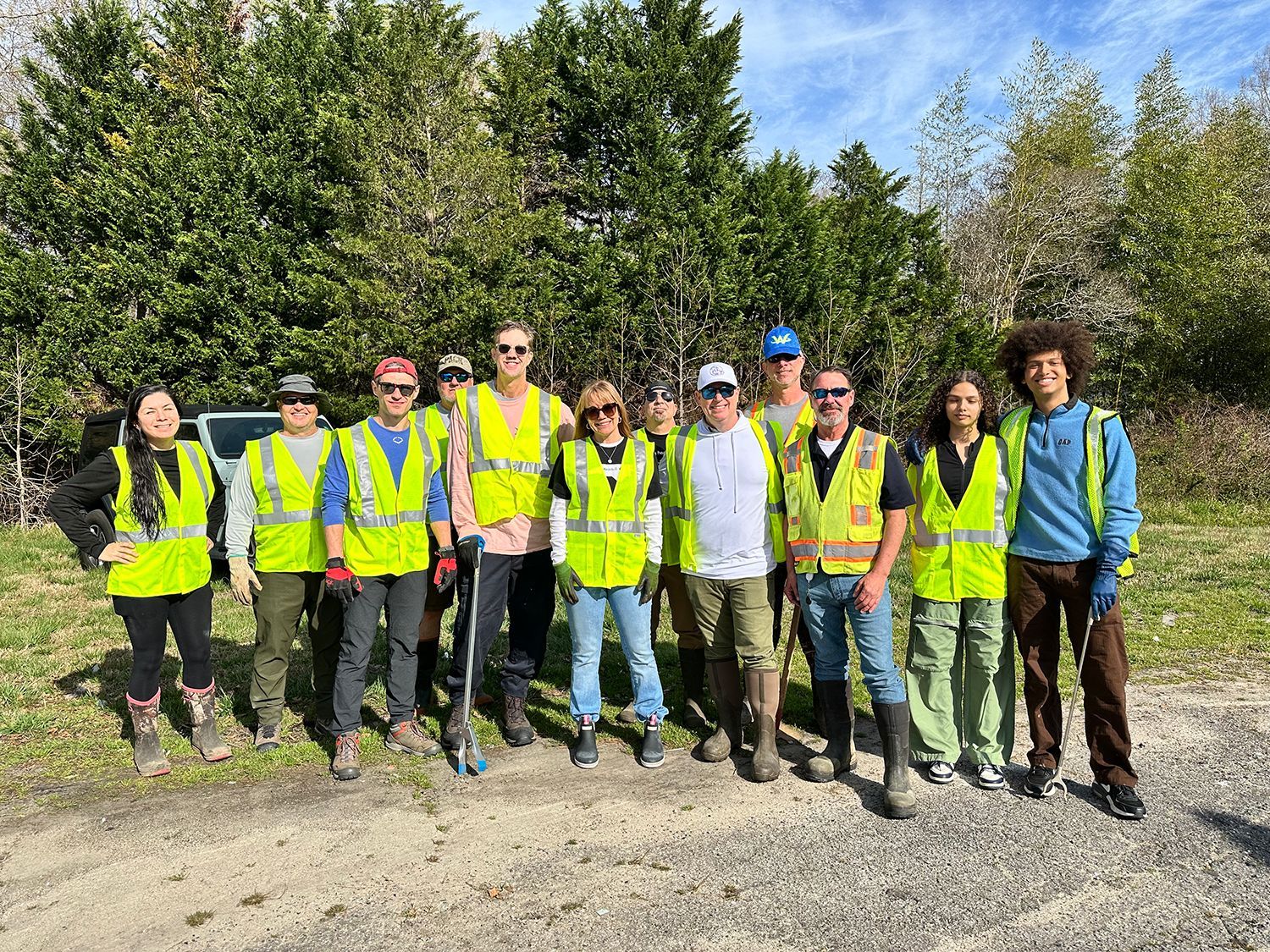 A group of people wearing yellow vests and boots are posing for a picture.