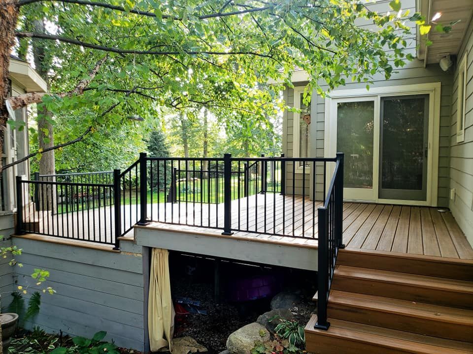 A deck with stairs leading up to it and a sliding glass door.