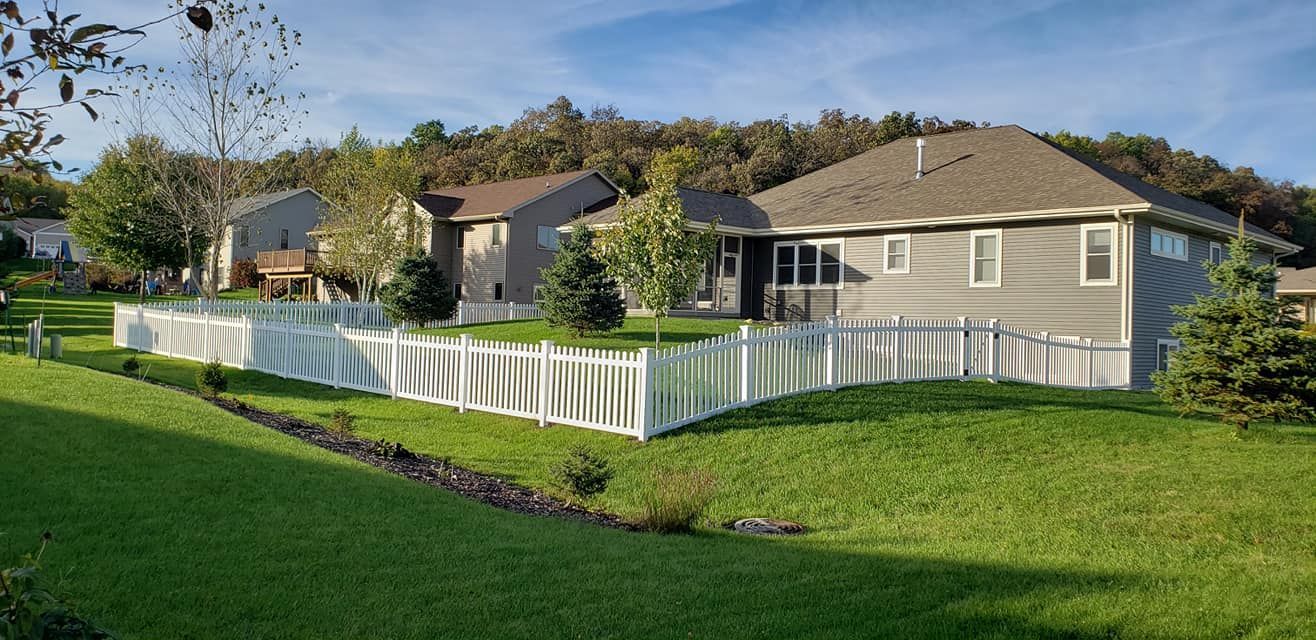 A house with a white picket fence in front of it.