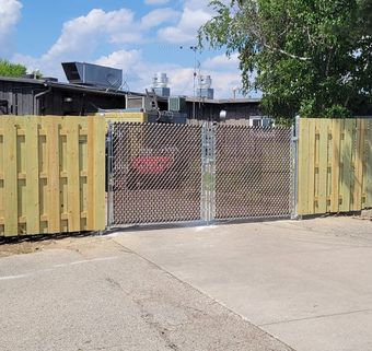 A wooden fence with a chain link fence behind it