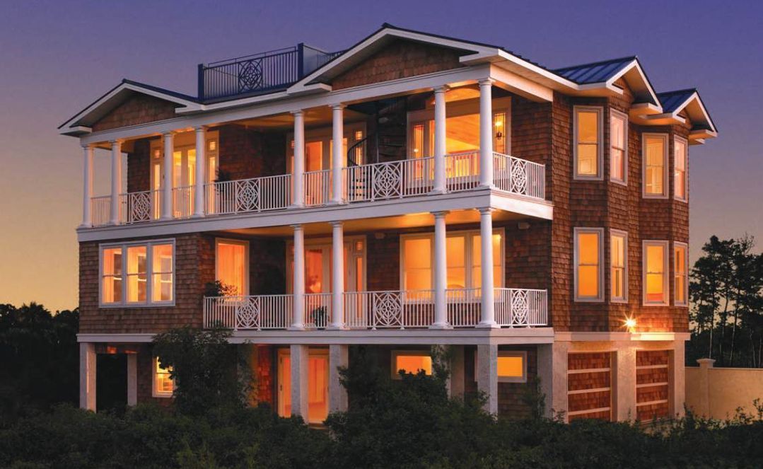 A large house with a lot of windows is lit up at night