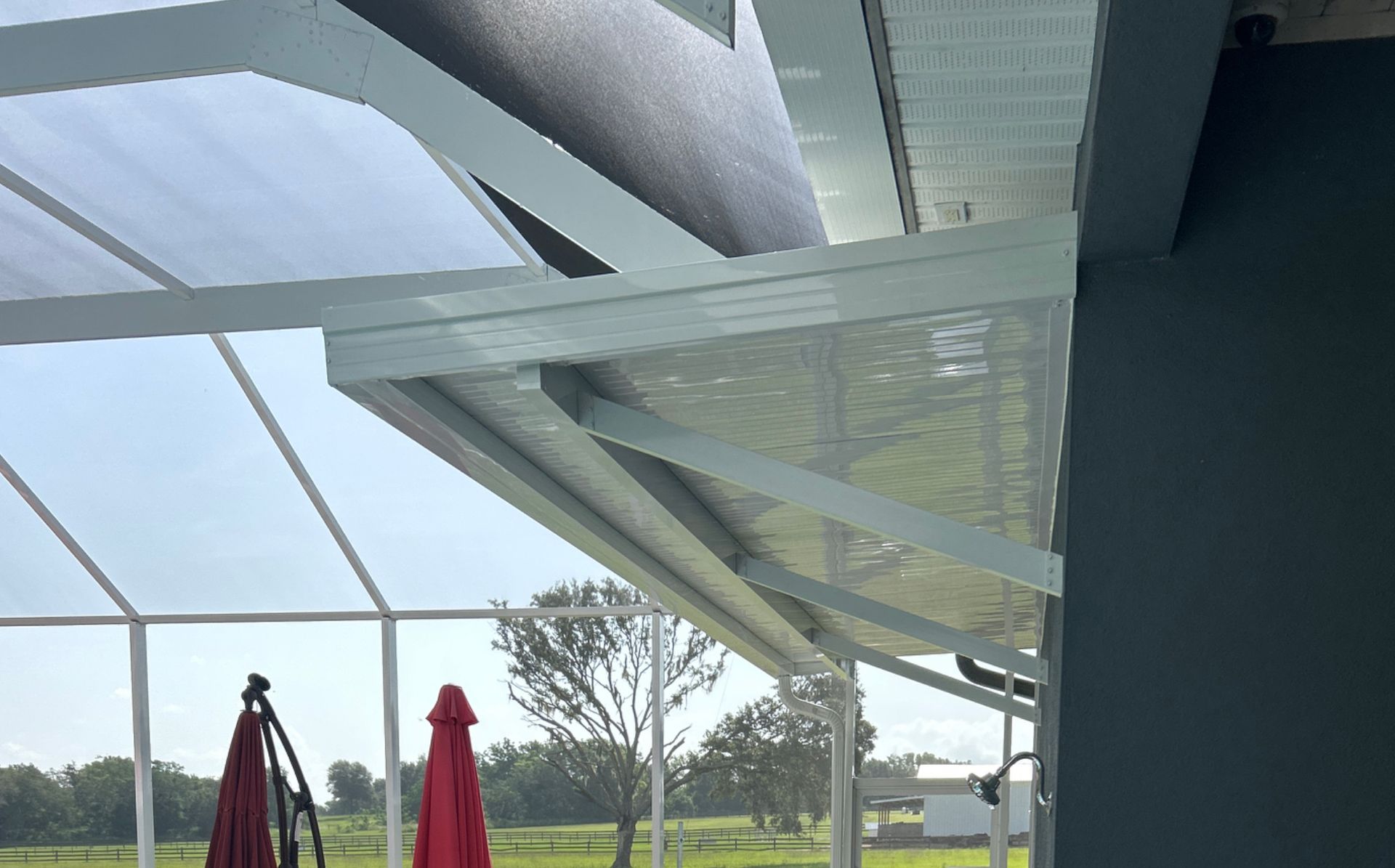 A white canopy over a patio with red umbrellas.