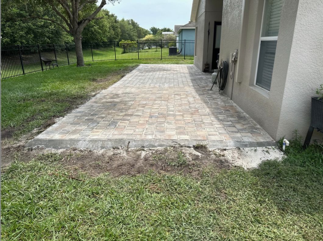 A brick walkway is being built in front of a house.