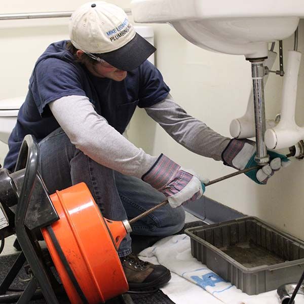 A man wearing a hat with the word plumbing on it