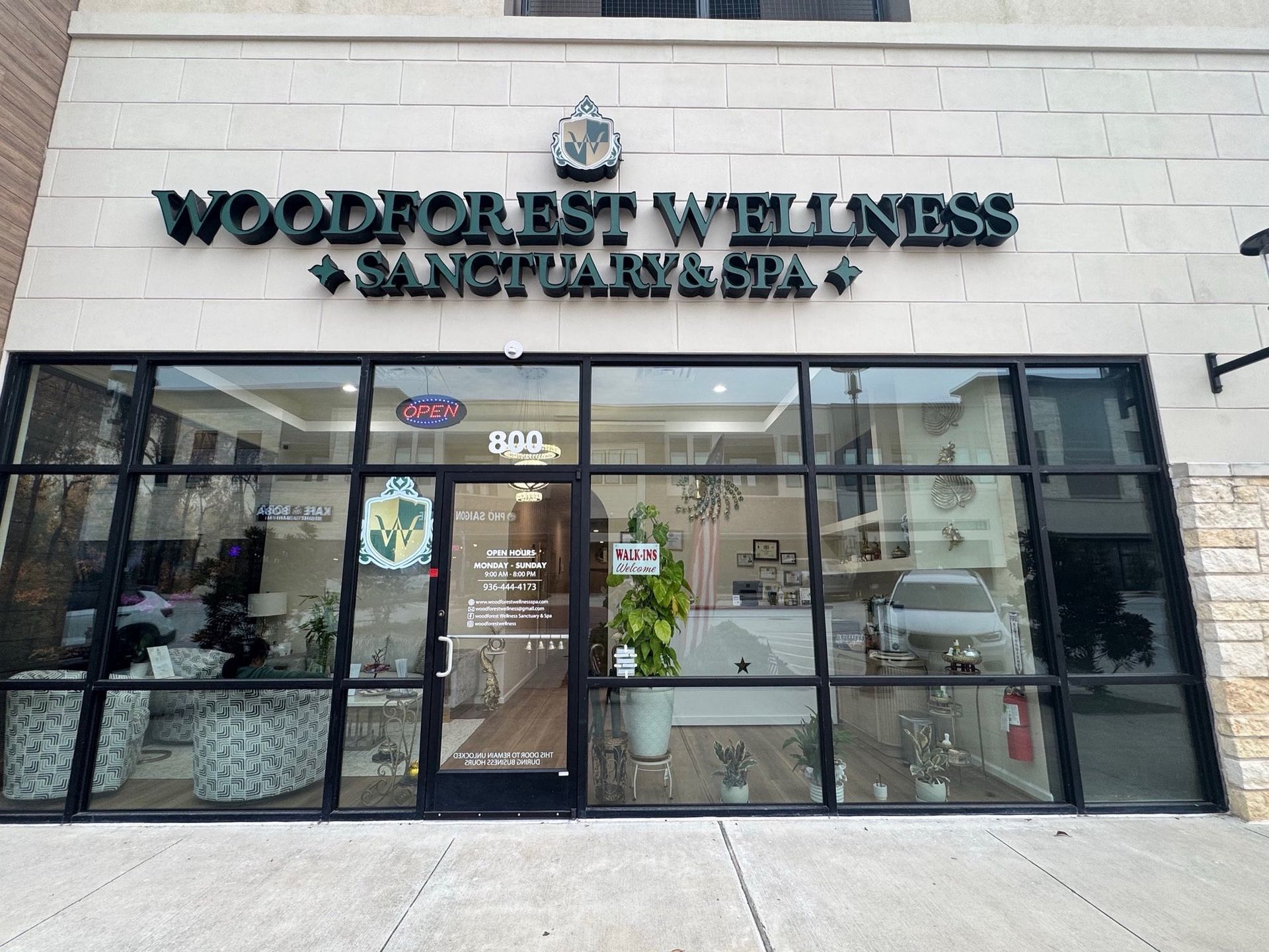 Woodforest Wellness Sanctuary & Spa storefront with a black framed glass entrance.