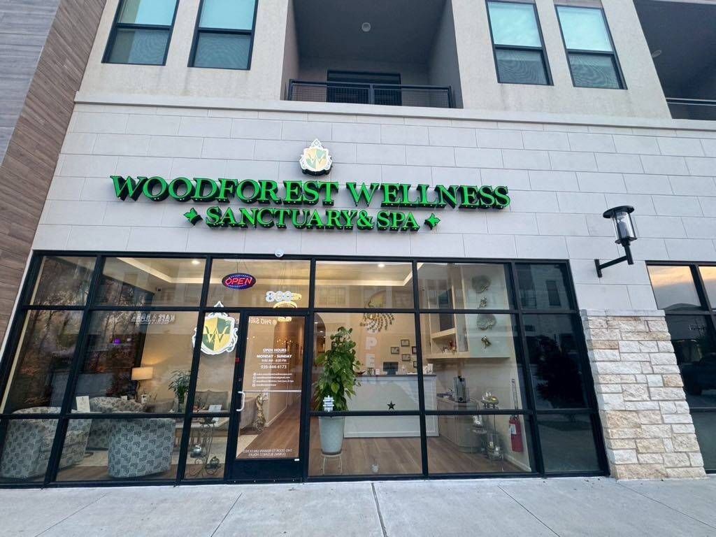 Woodforest Wellness Sanctuary & Spa storefront with green signage, glass windows, and stone exterior.