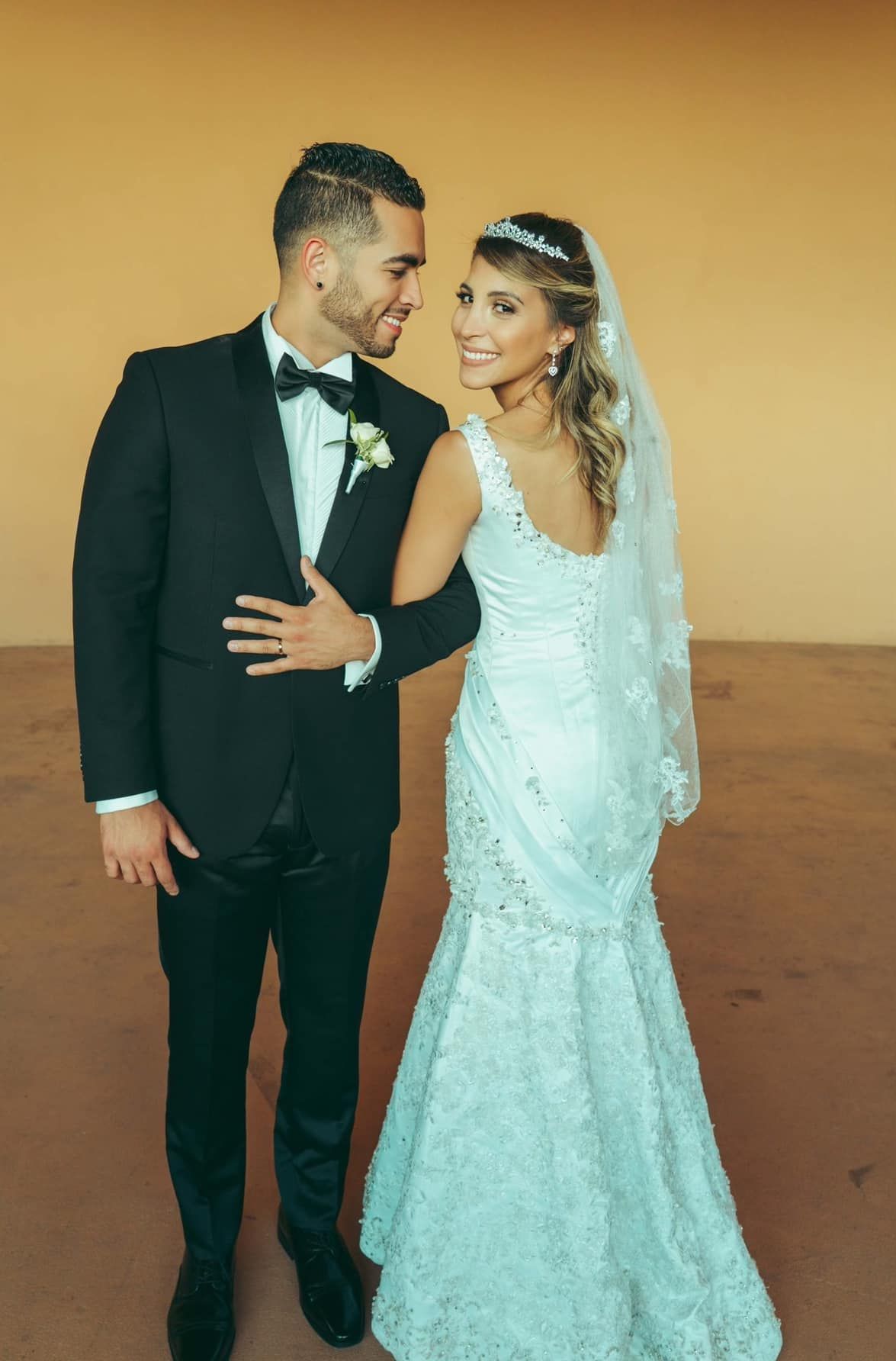 A bride and groom are posing for a picture on their wedding day.