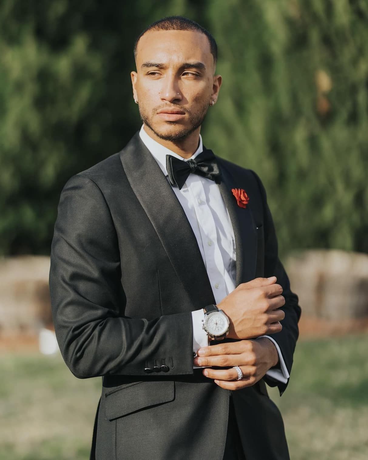 A man in a tuxedo with a watch on his wrist