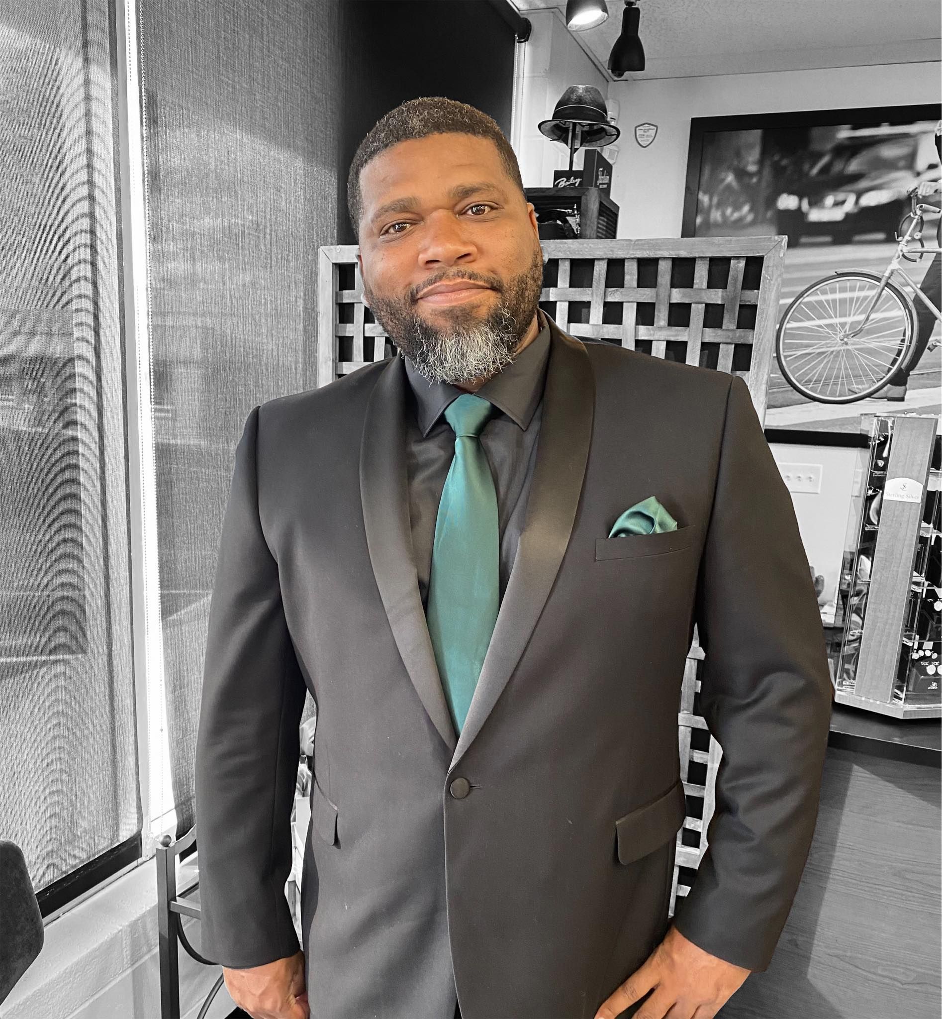 A man in a suit and tie is standing with his hands on his hips.