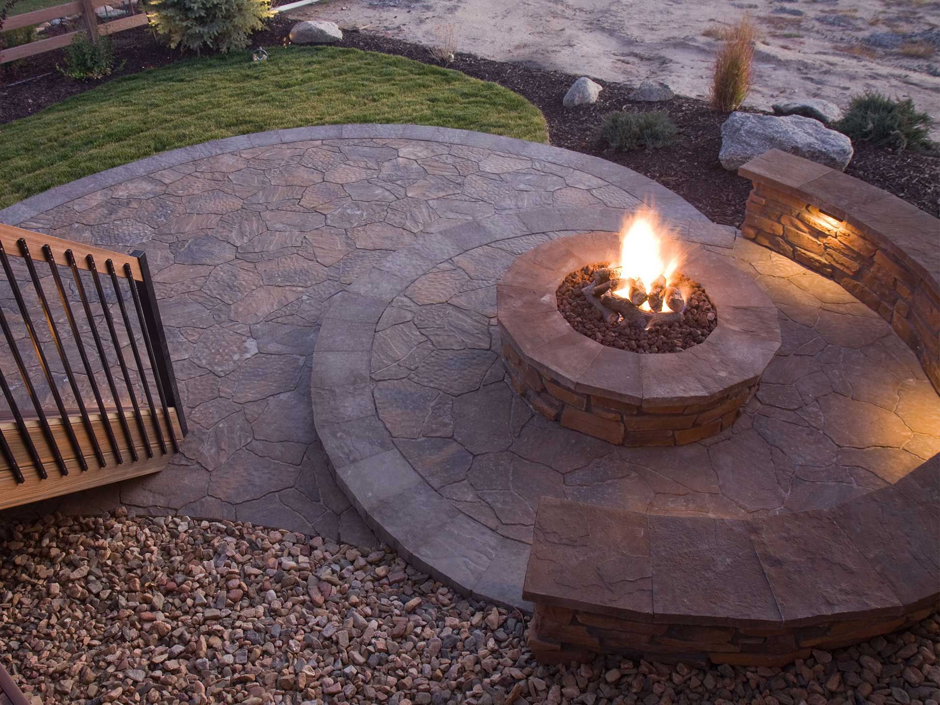 a fire pit is lit up in the middle of a patio