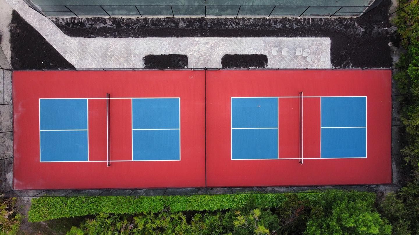 Red building facade with four blue windows, viewed from above.