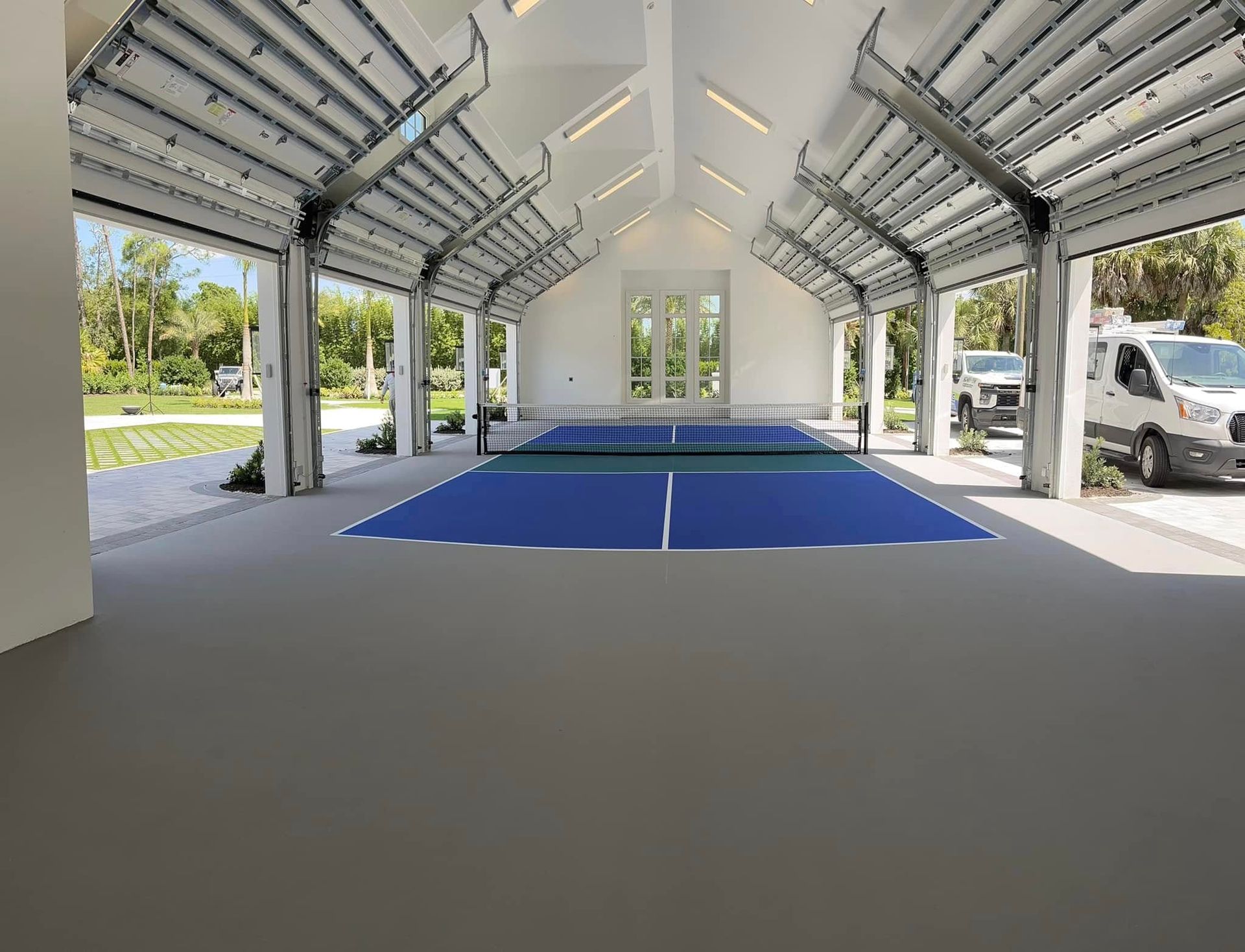 Open-sided pavilion with a blue floor mat and white walls, viewed from the entrance.