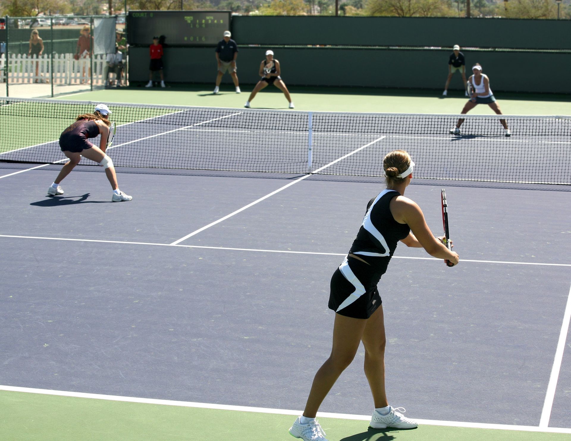 Two tennis players at the net during a doubles match on an outdoor court