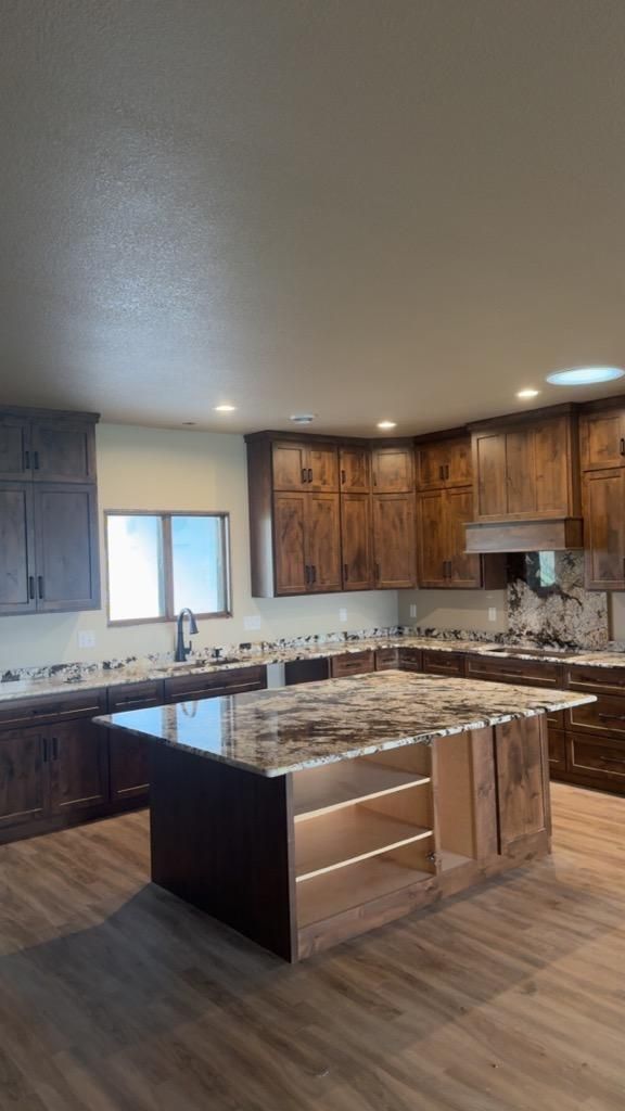 Spacious modern kitchen with wood cabinets, granite island, and stainless steel appliances