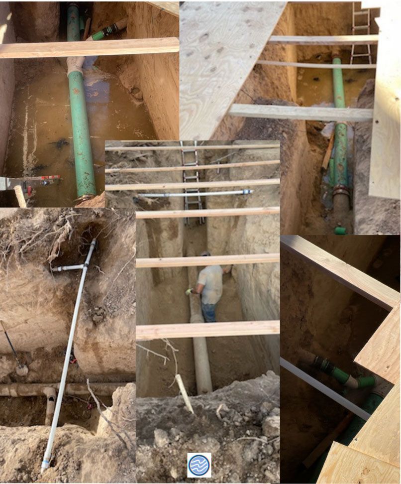 Construction site with exposed dirt trench, wooden framing, pipes, and temporary support braces