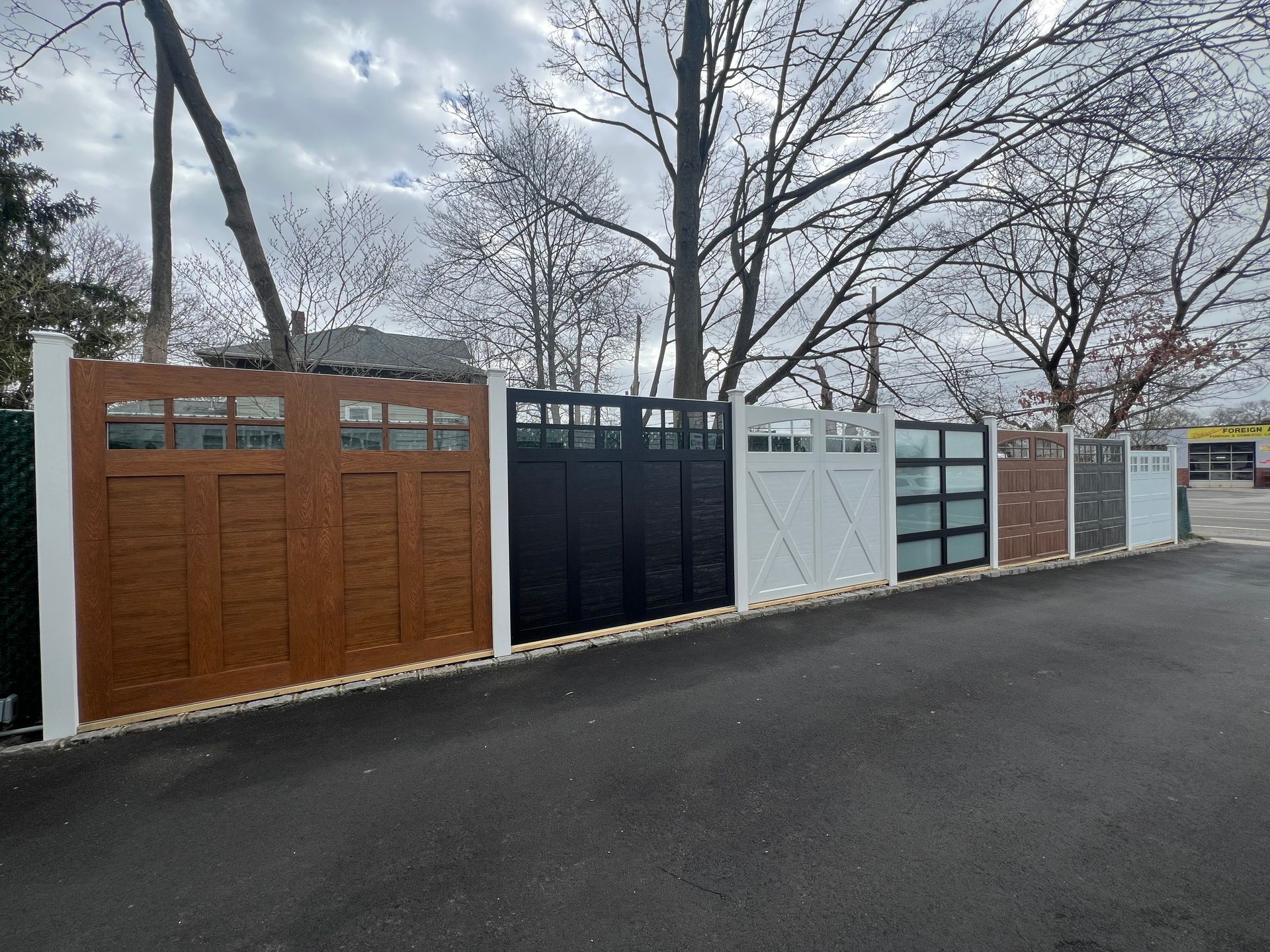 Exterior display of multiple garage doors in various styles and colors.
