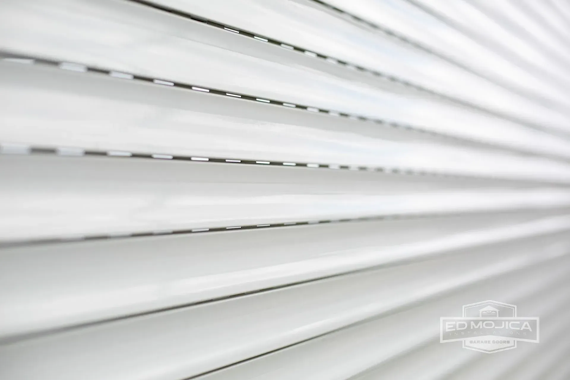 Close-up of white horizontal blinds with angled lines and some visible gaps.