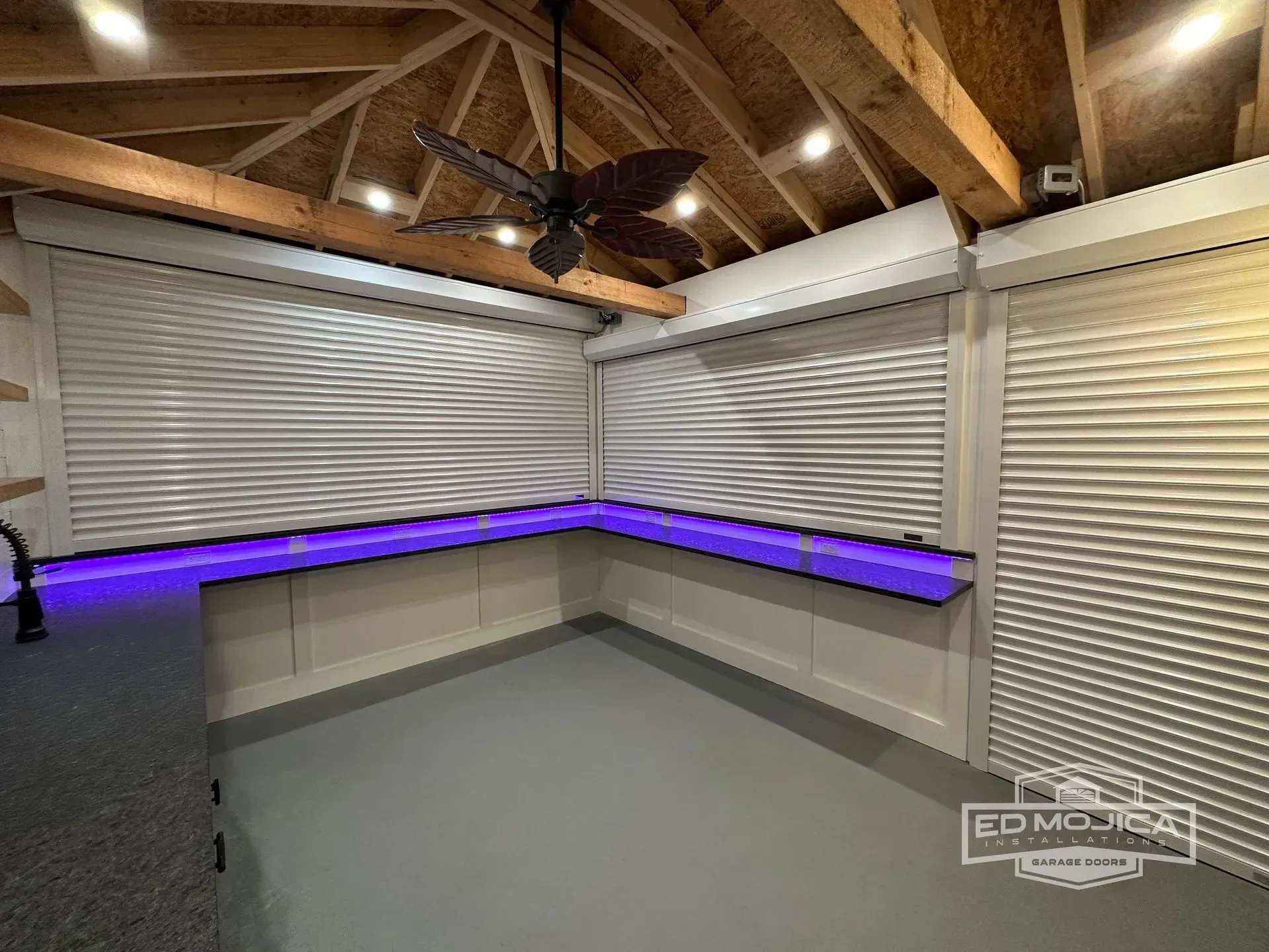 Interior room with white shutters, a purple lit countertop, and a ceiling fan.