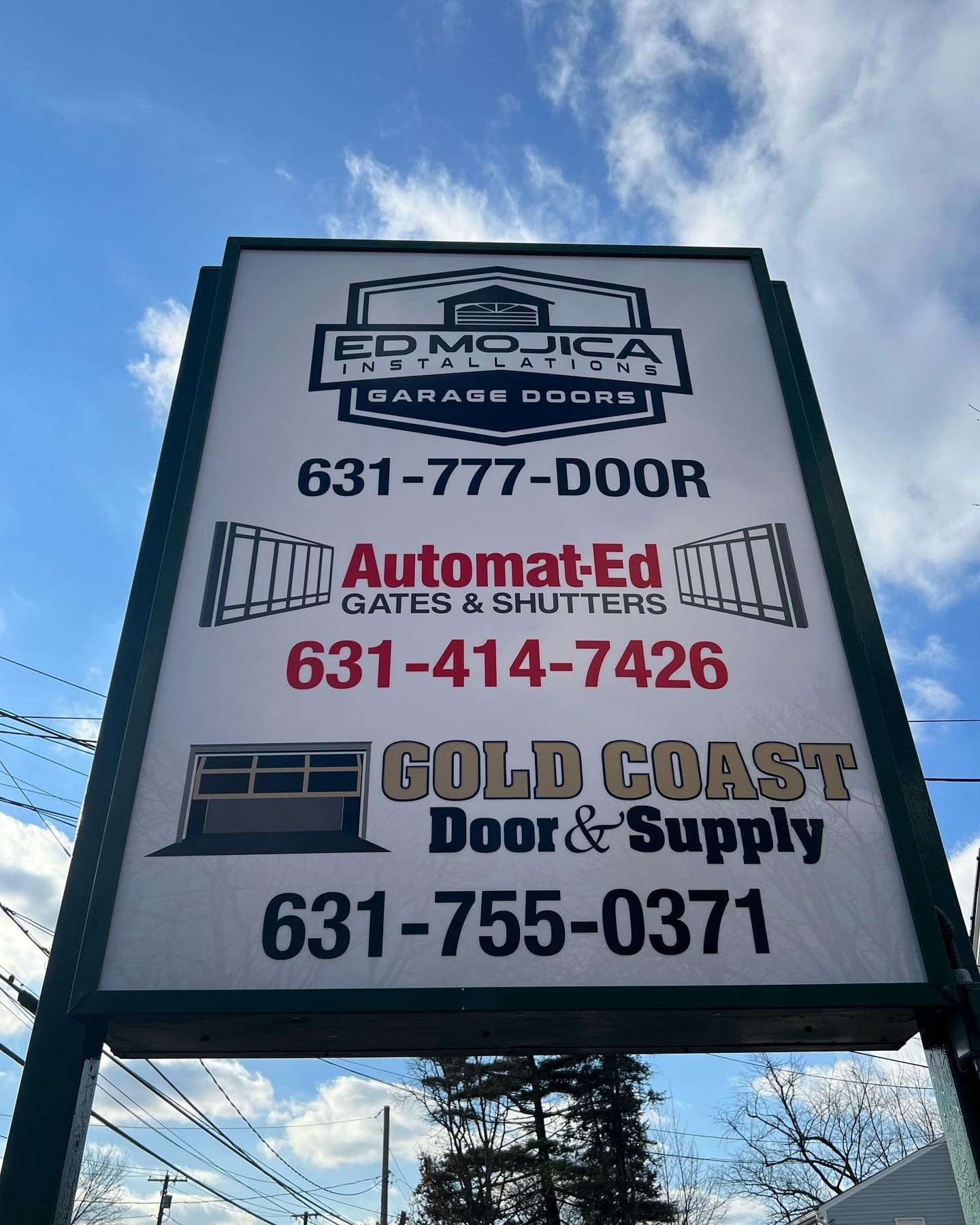 Sign for garage door services with contact numbers.