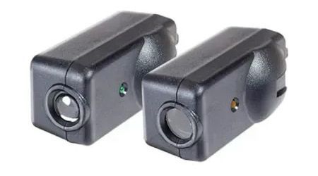 Two black security cameras, cylindrical lens and a green or yellow LED on the face.
