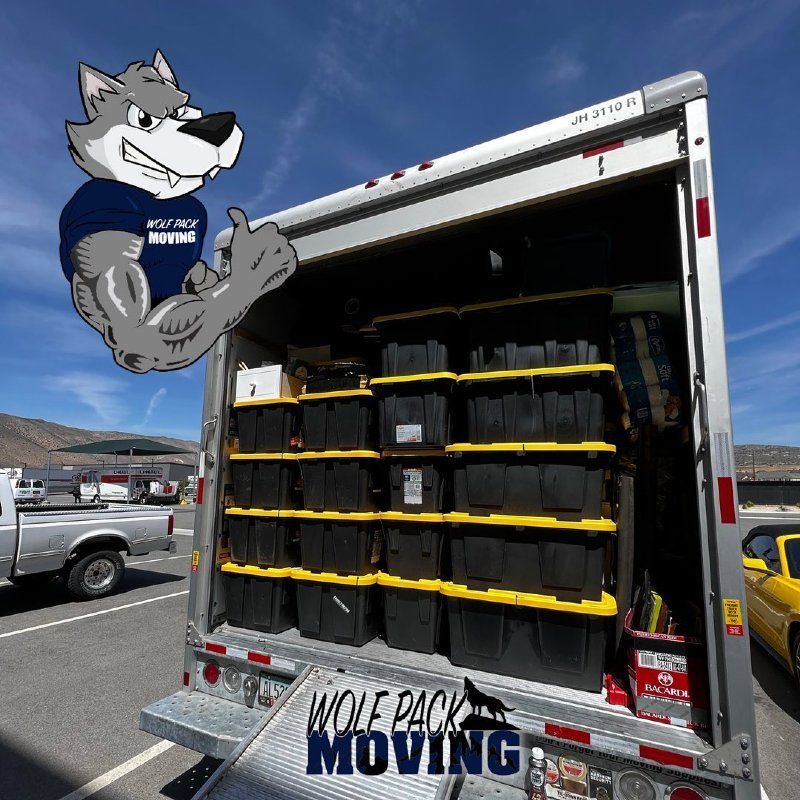 Strong wolf mascot gives thumbs up next to a moving truck packed with black containers.