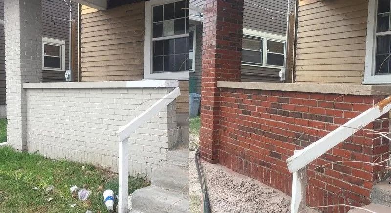 Front steps and brick-and-siding townhouse entry with white railings and small grass strip
