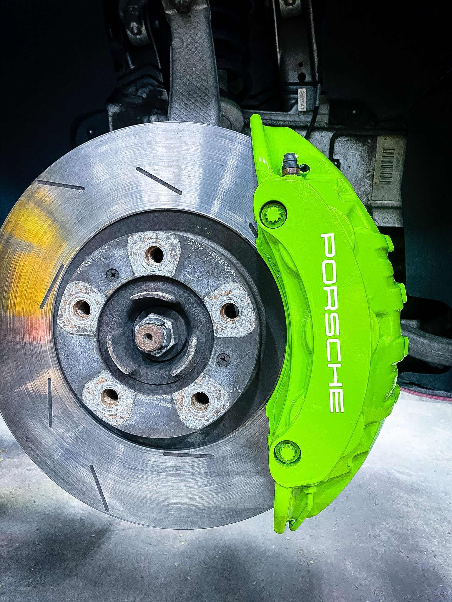 A close up of a porsche brake caliper on a car