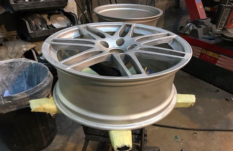 A car wheel is sitting on a table next to a trash can.