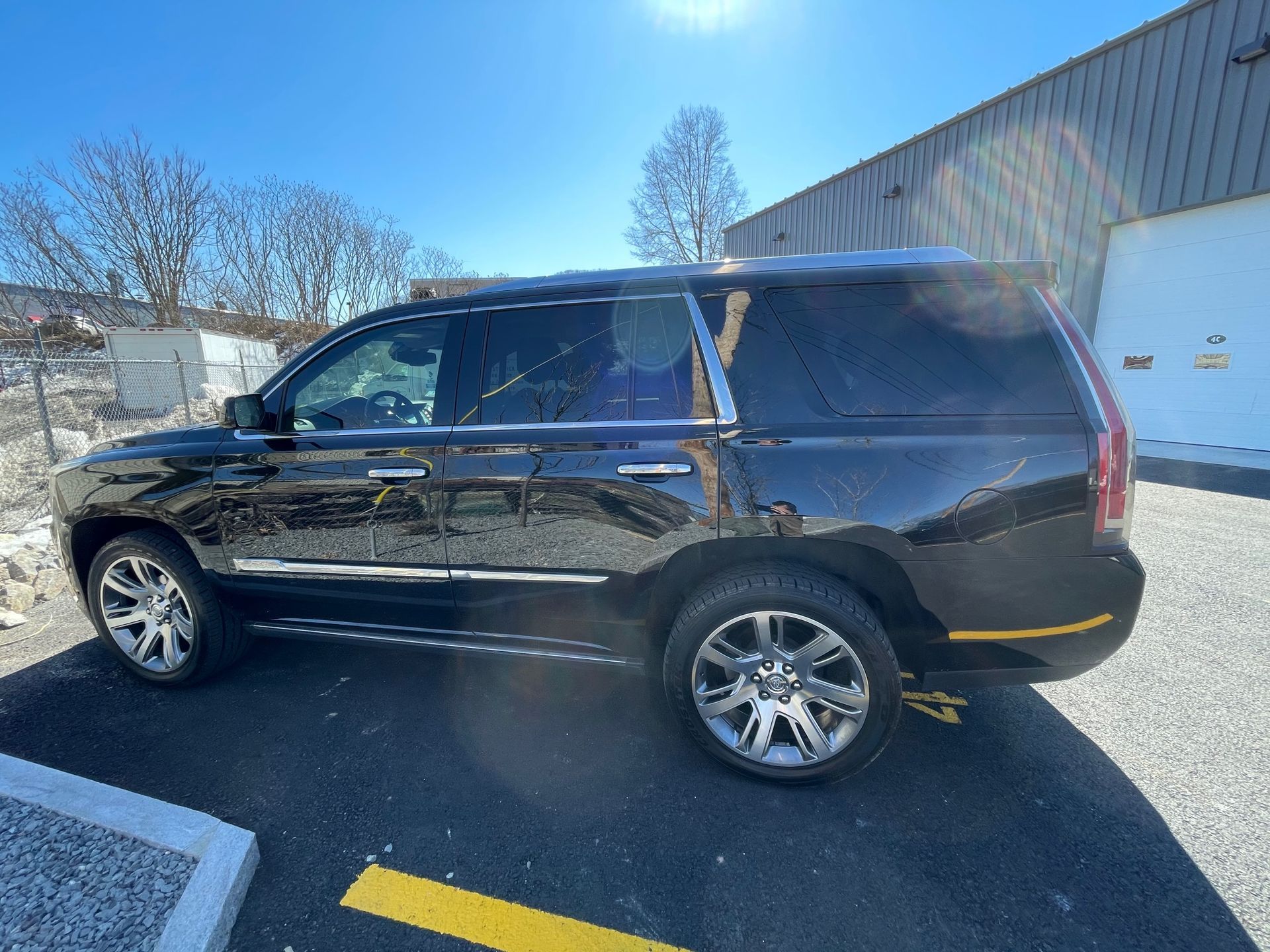 A black suv is parked in a parking lot in front of a building.