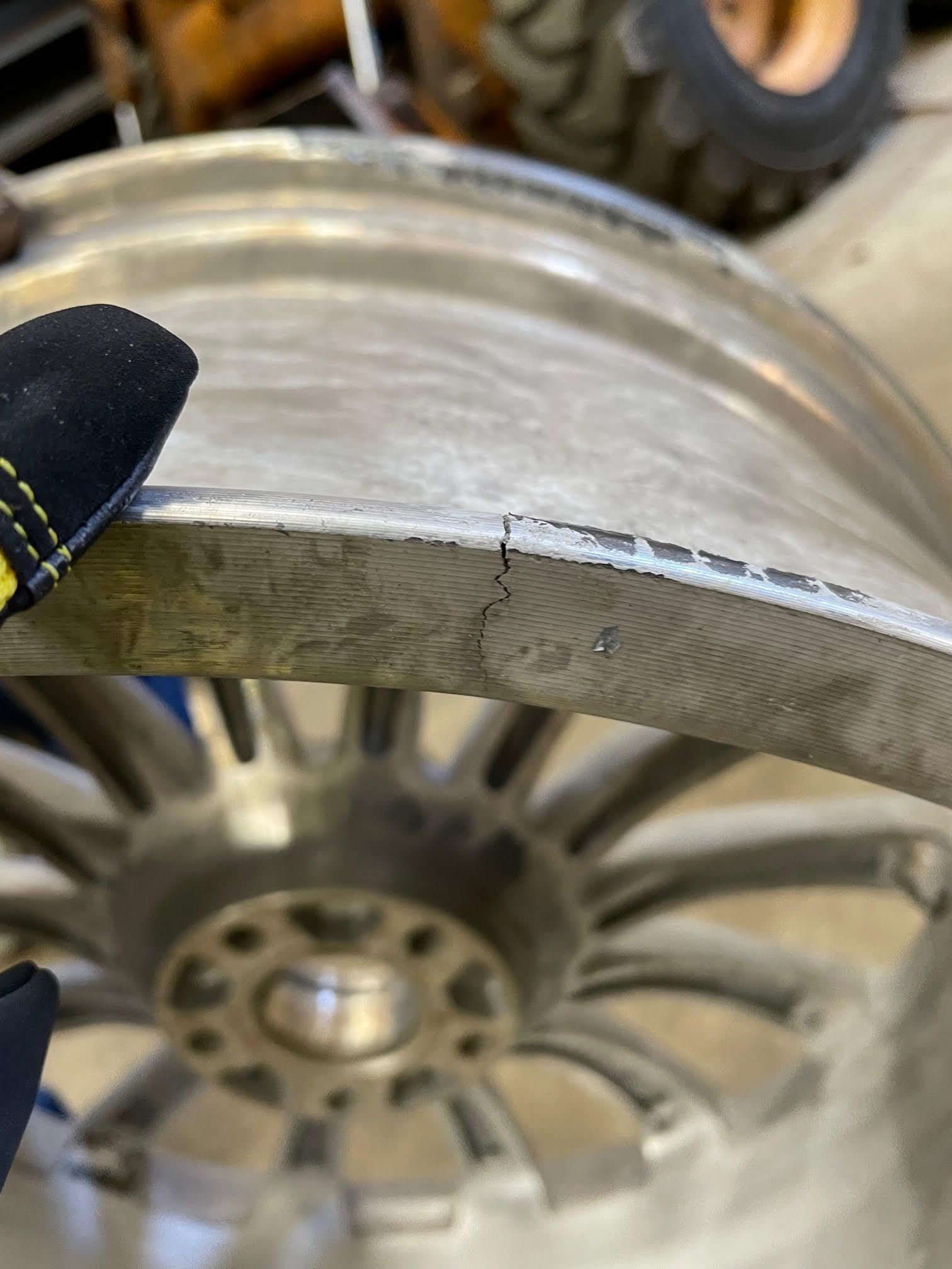 A person is holding a wheel with a glove on it.