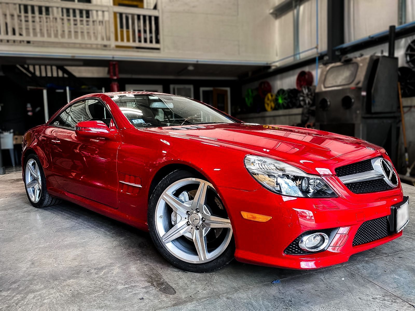 A red sports car is parked in a garage.