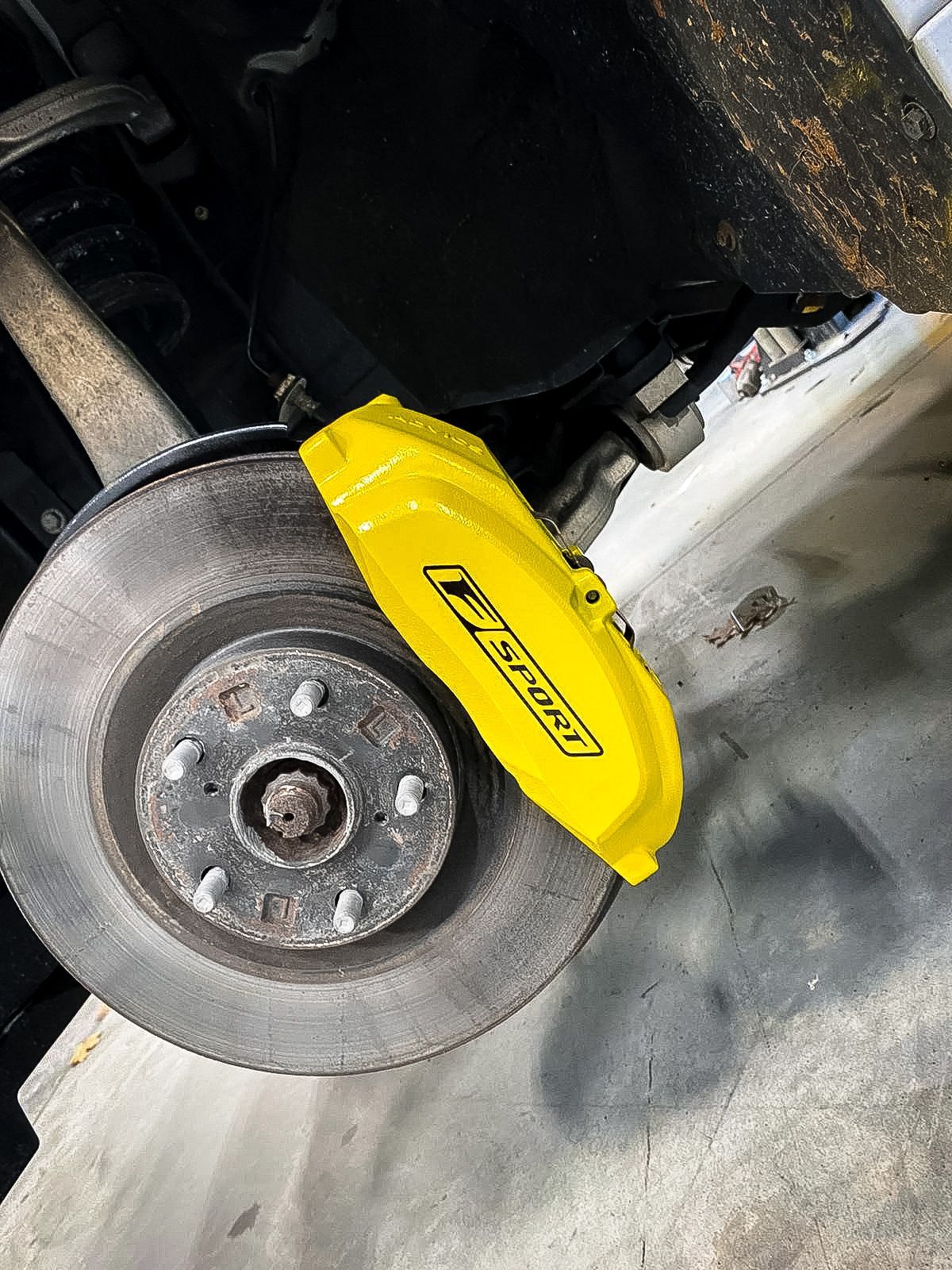 A close up of a yellow brake caliper on a car.