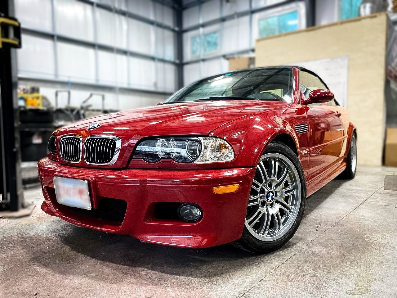 A red bmw m3 is parked in a garage.