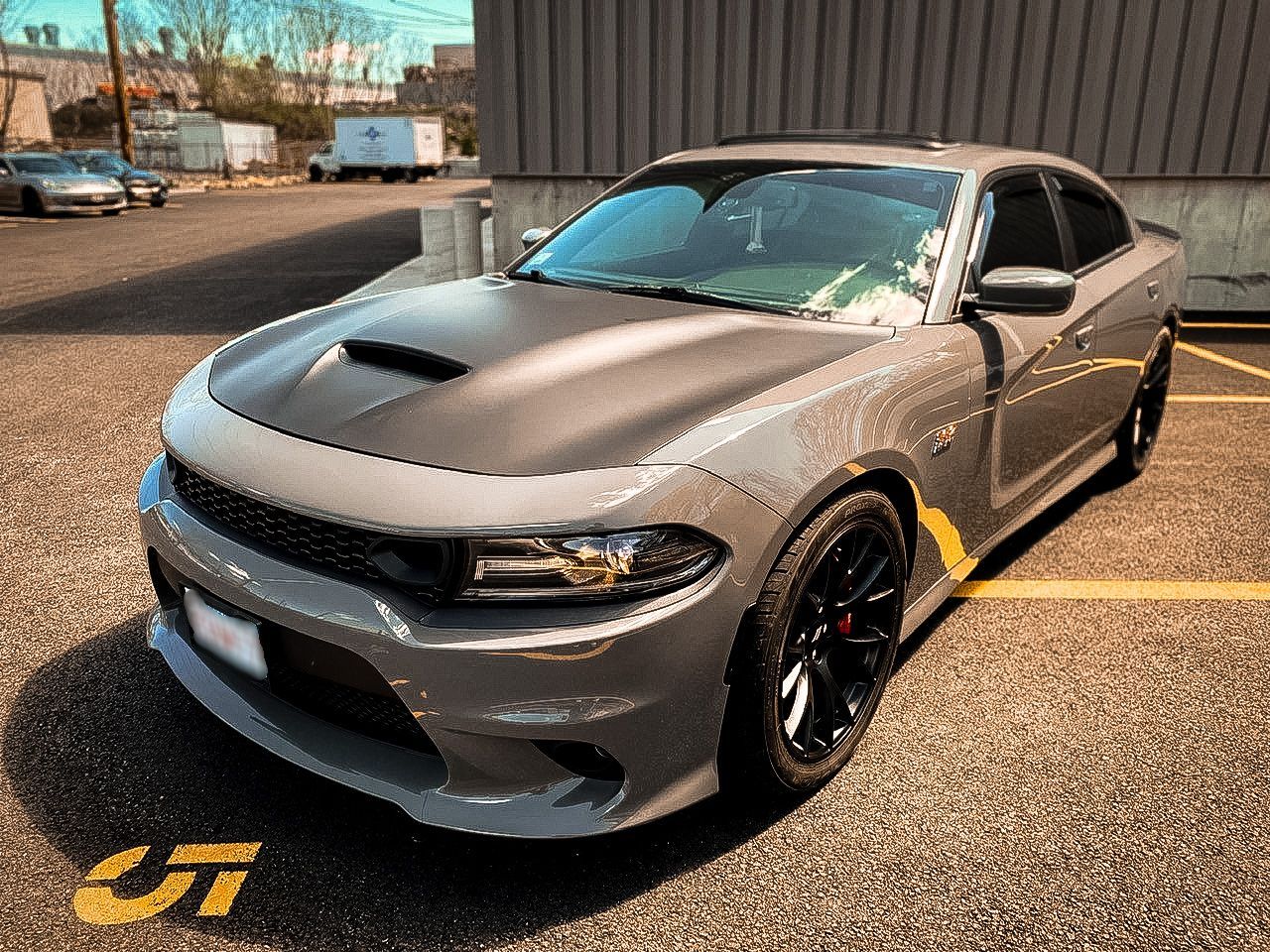 A gray dodge charger is parked in a parking lot.