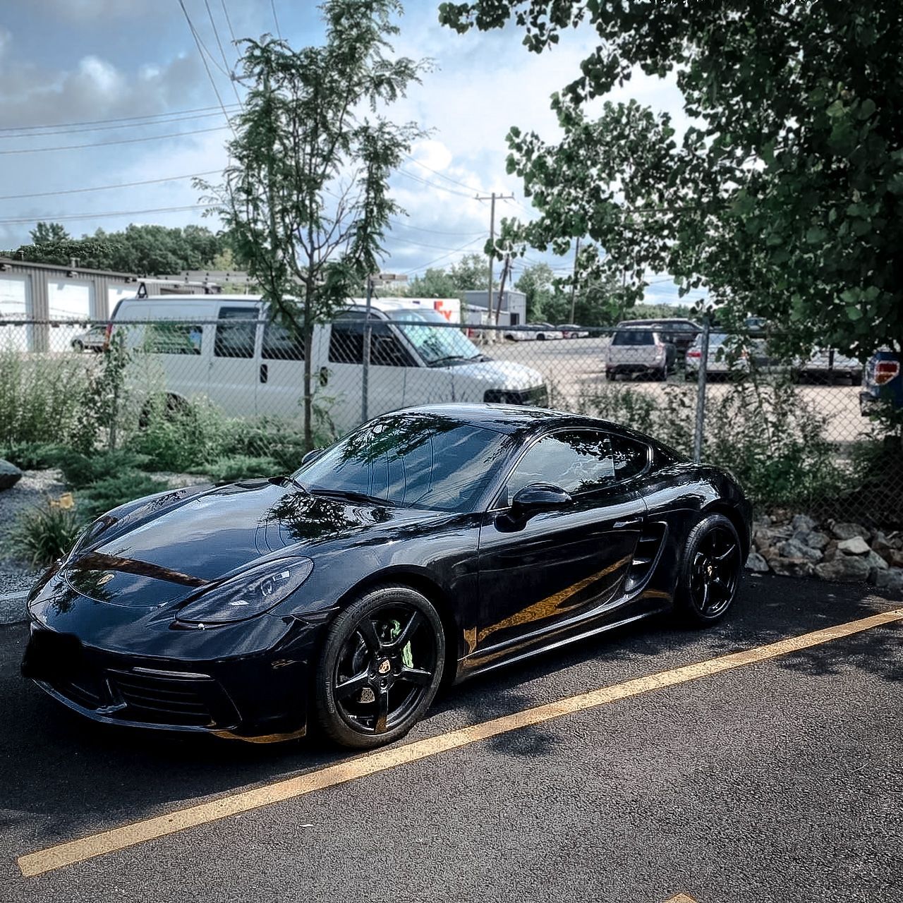 A black sports car is parked on the side of the road