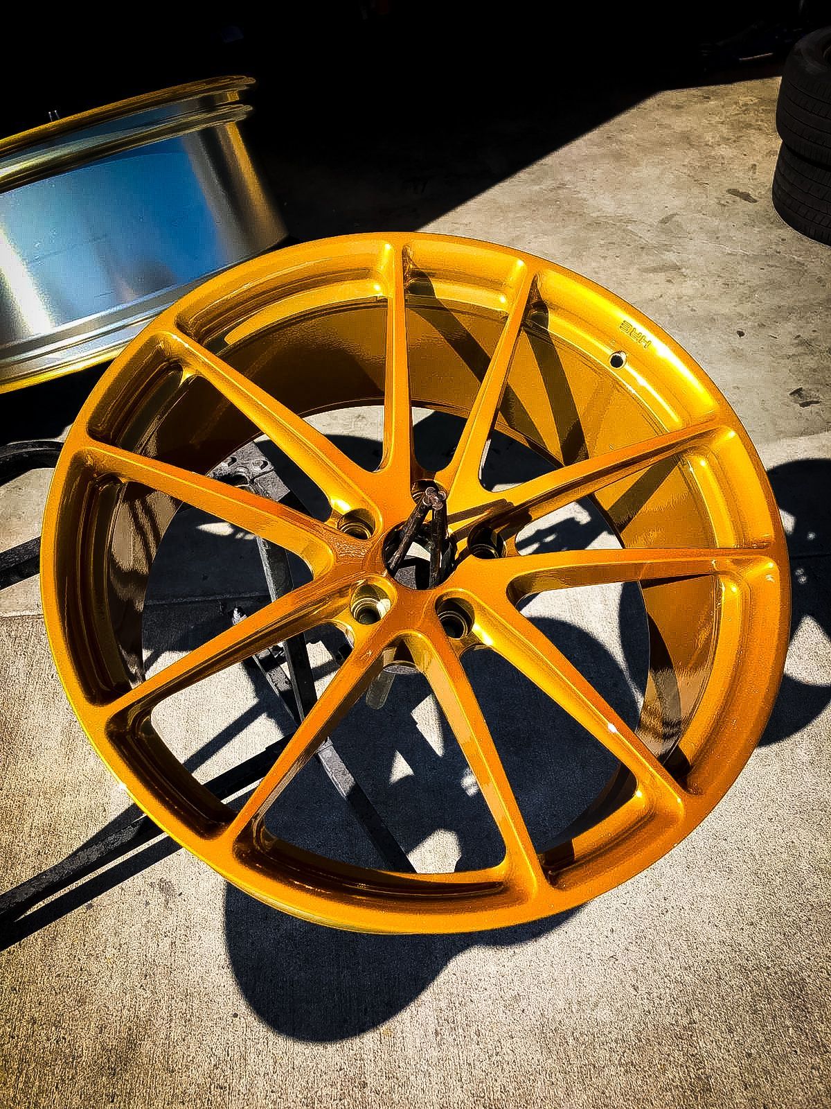 A close up of a yellow wheel on a concrete surface.