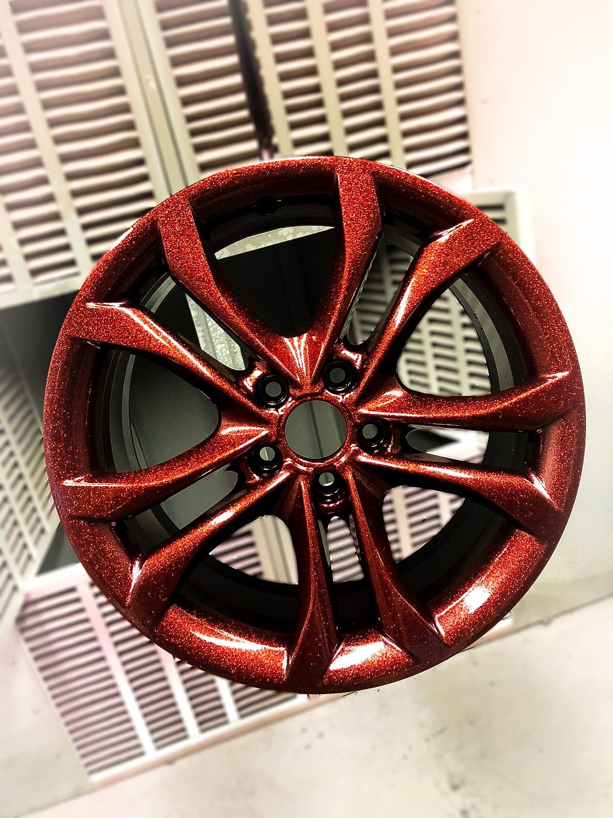 A red wheel with glitter on it is sitting on a table.