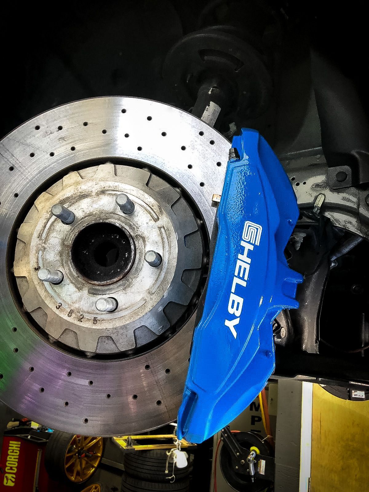 A close up of a blue brake caliper on a car.
