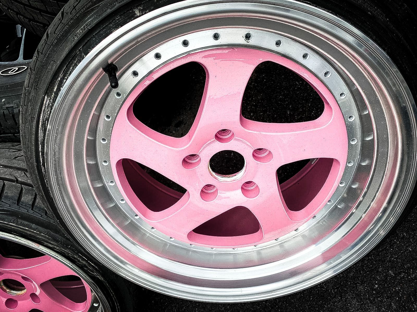A close up of a pink wheel on a car