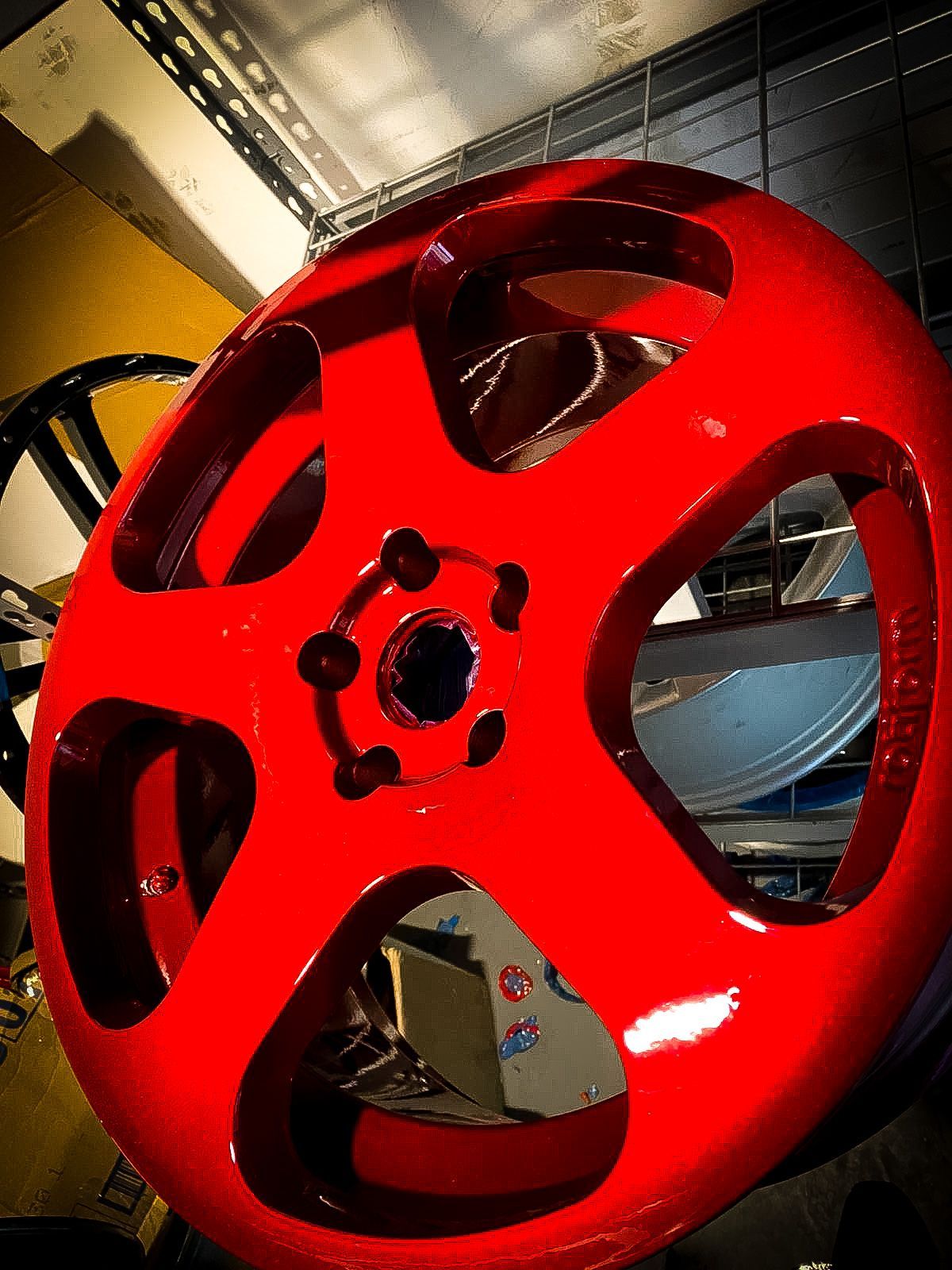 A close up of a red wheel in a garage