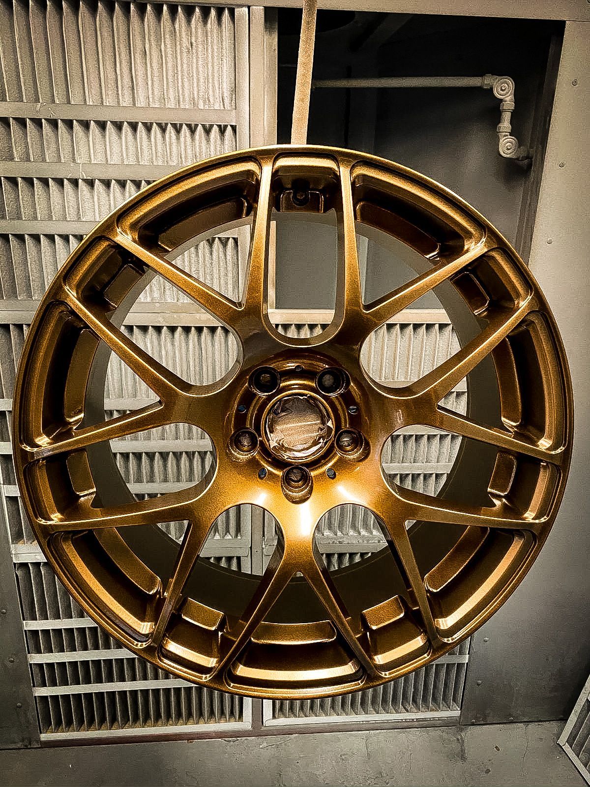 A close up of a gold car wheel in a garage.