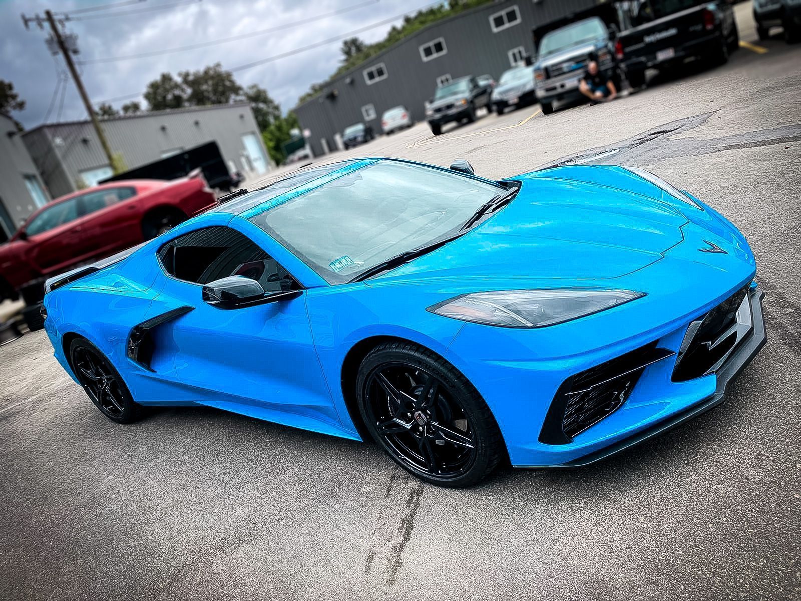 A blue sports car is parked in a parking lot.