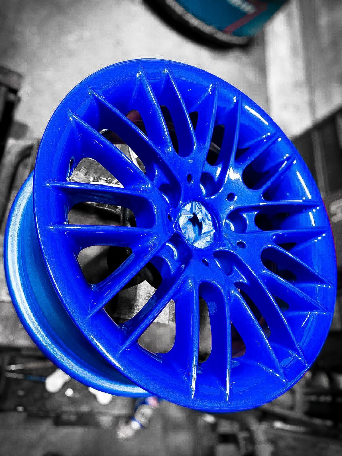 A blue wheel is sitting on a table in a garage.