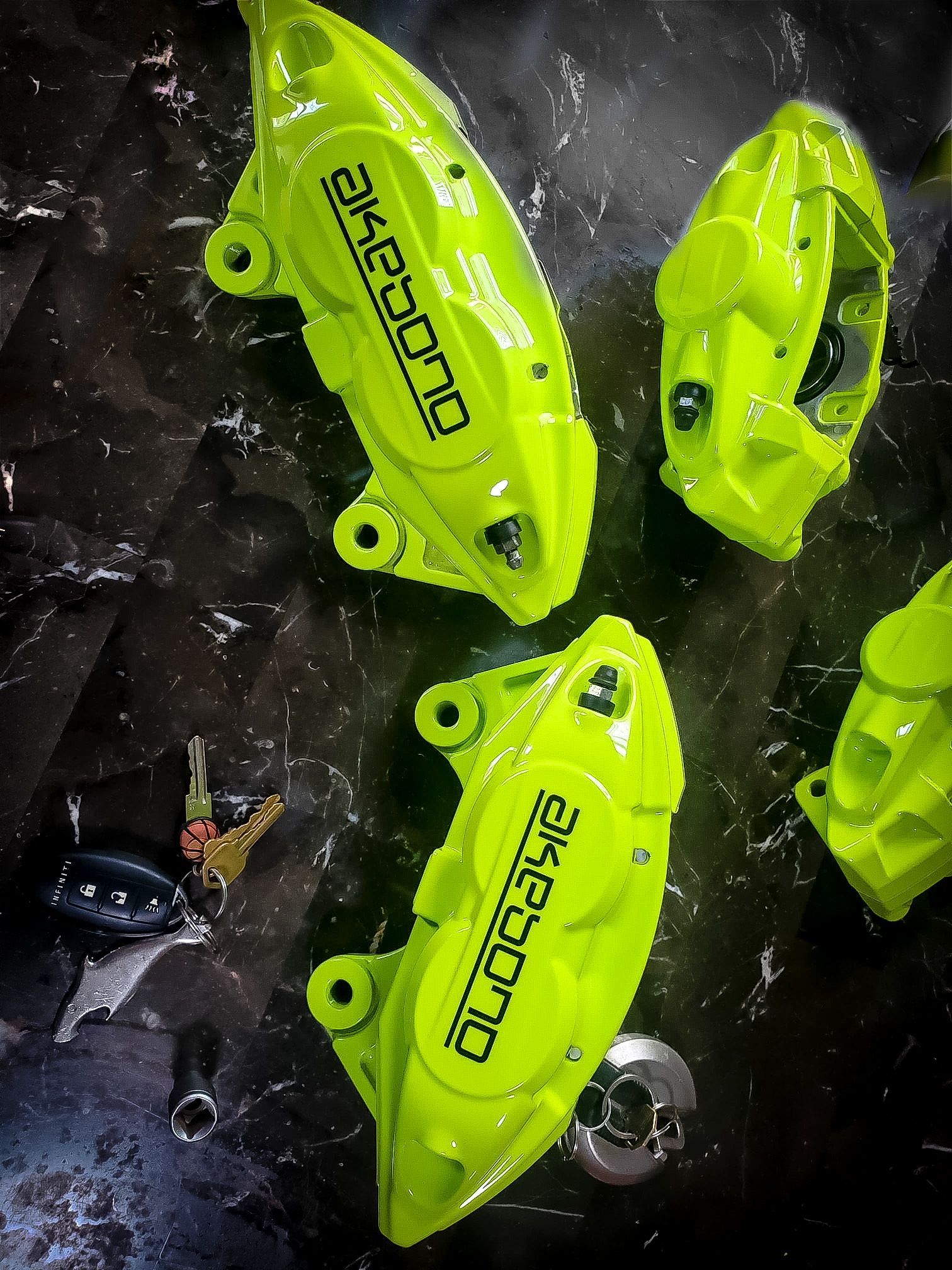 A pair of neon yellow brake calipers are sitting on a table.