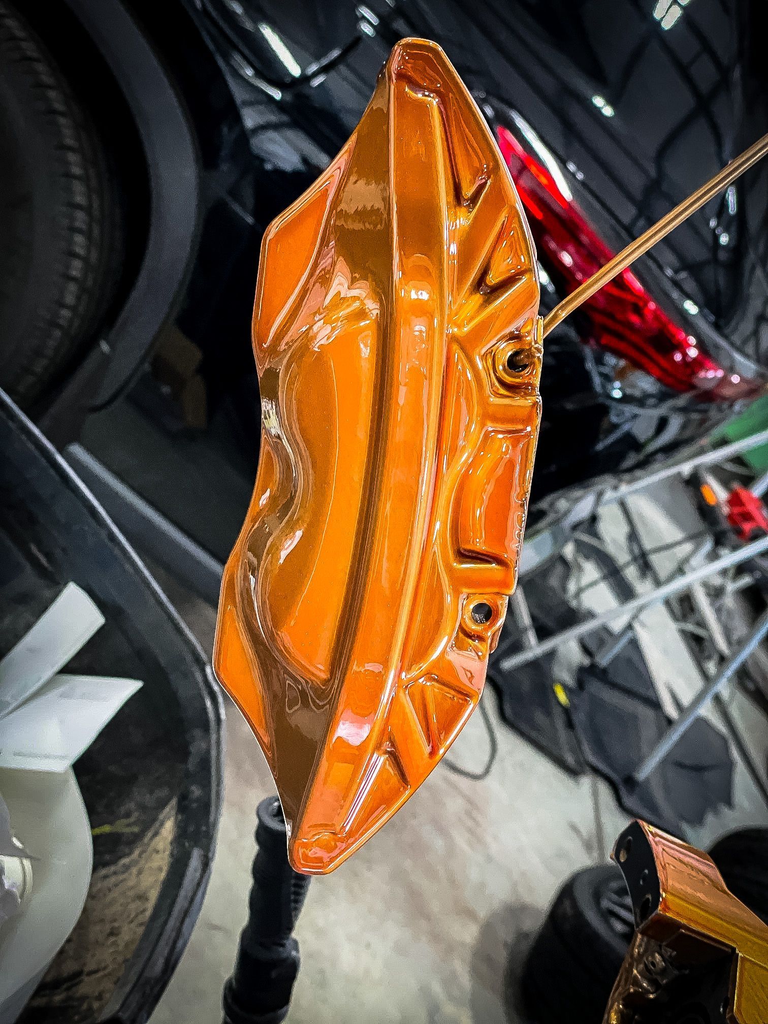 A close up of an orange brake caliper on a car.