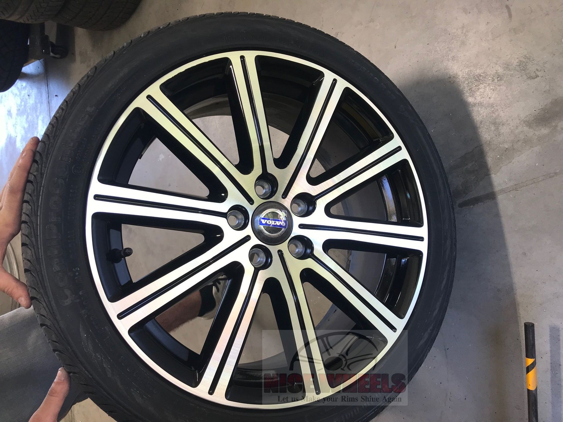 A person is holding a volvo wheel in their hand