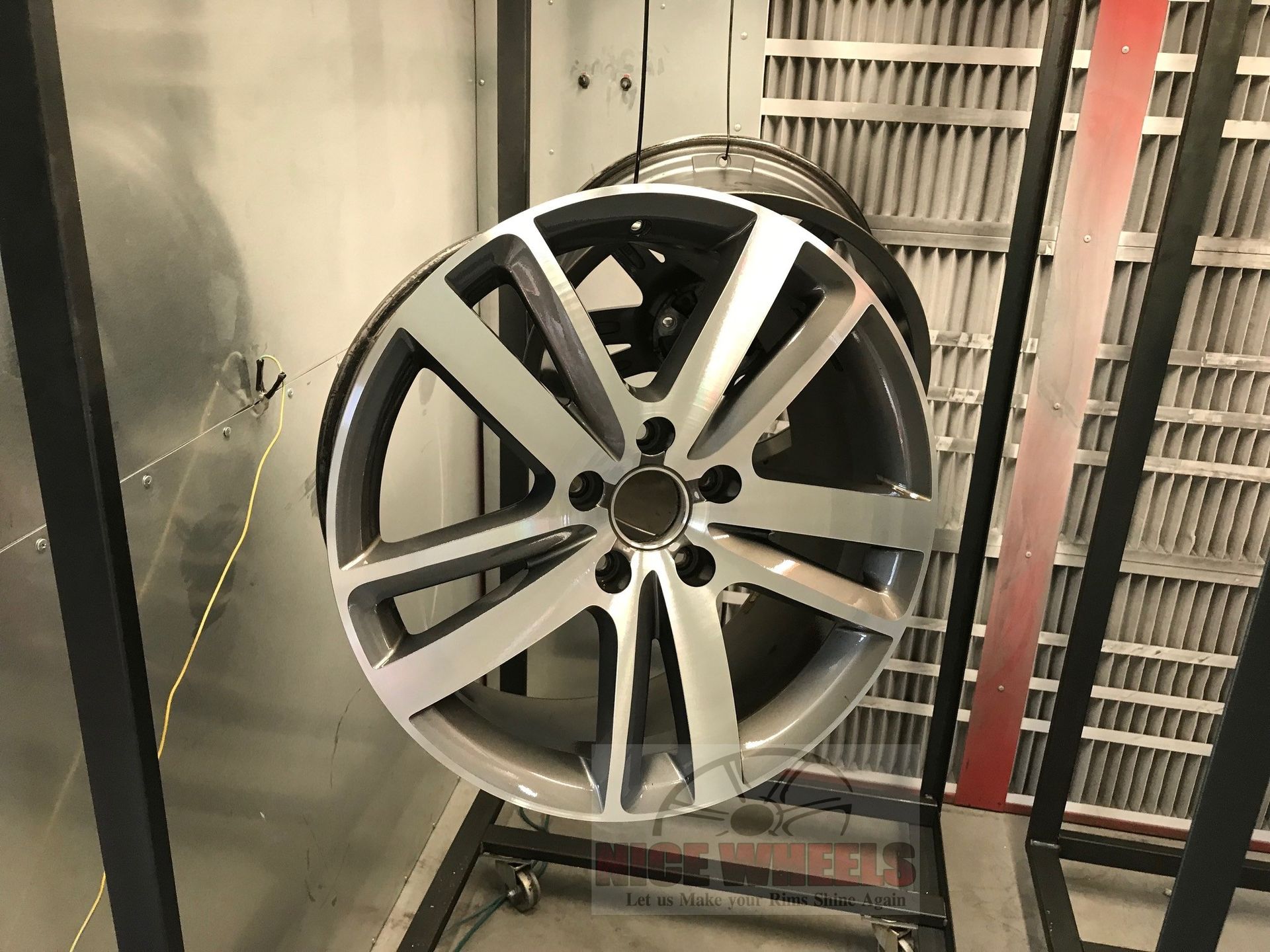 A car wheel is sitting on a rack in a room.